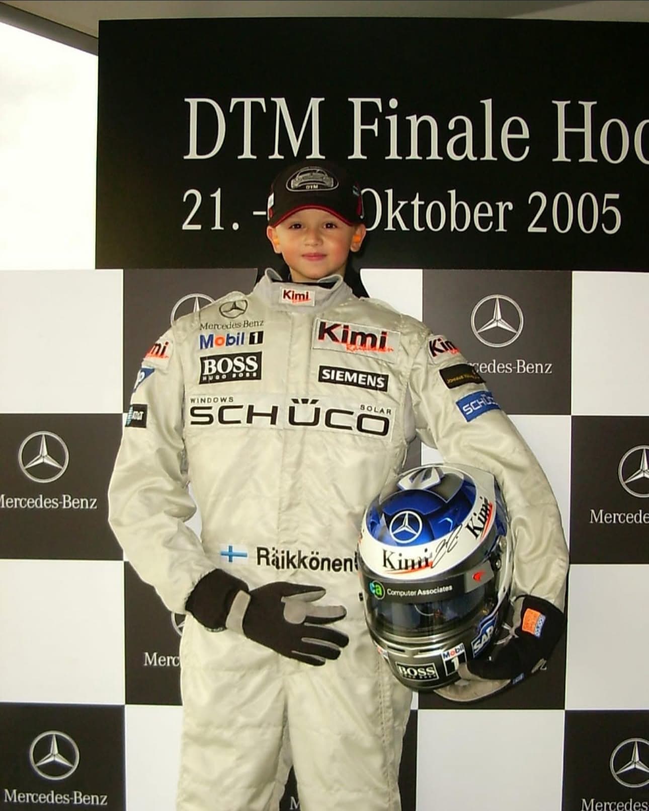 Marcel as a child in a replica race suit holding a helmet at the DTM finale, Hockenheim 2005
